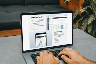 a man using a laptop computer on a table by PiggyBank courtesy of Unsplash.